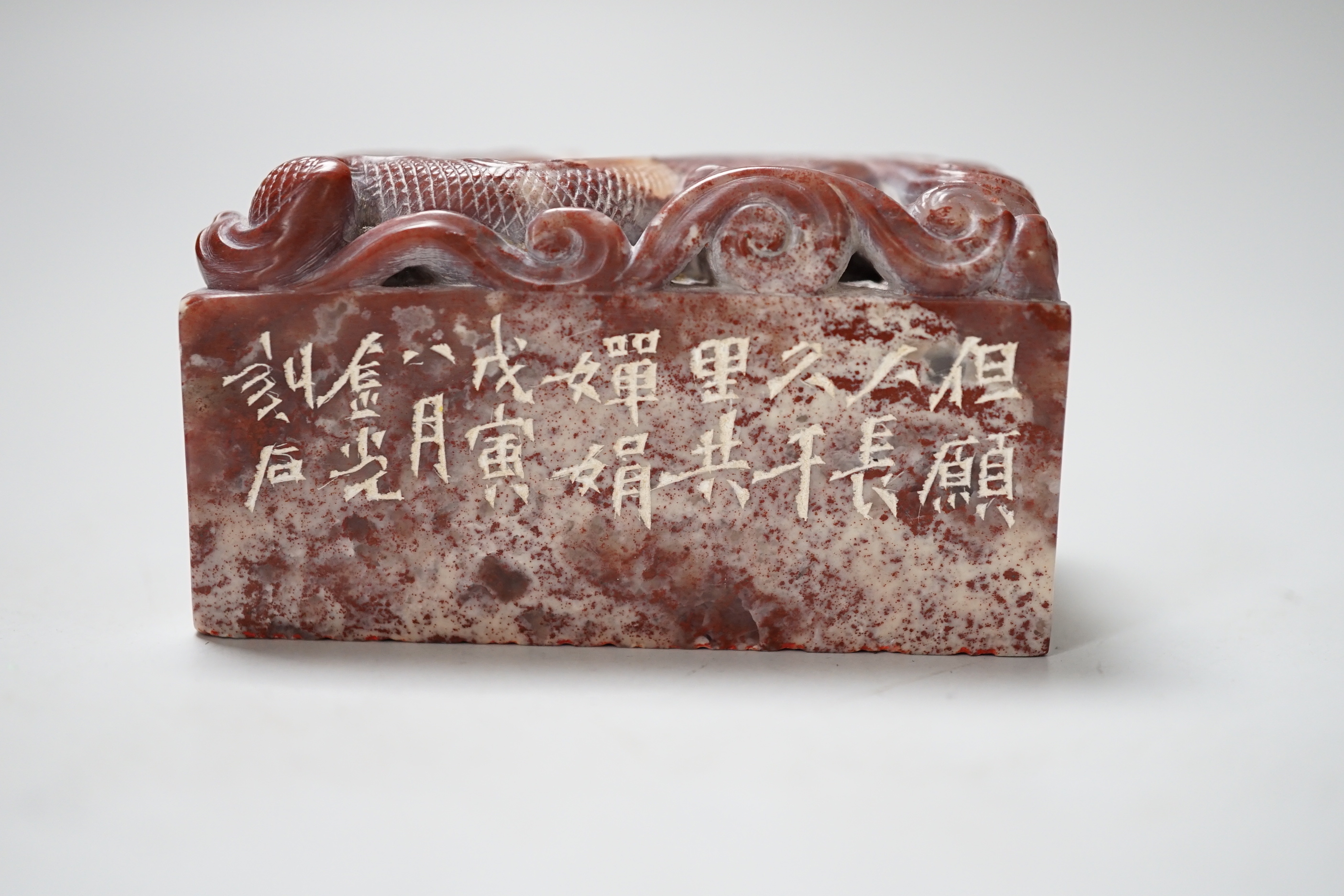 A Chinese chicken’s blood inscribed soapstone seal, carved with a dragon, 6cm